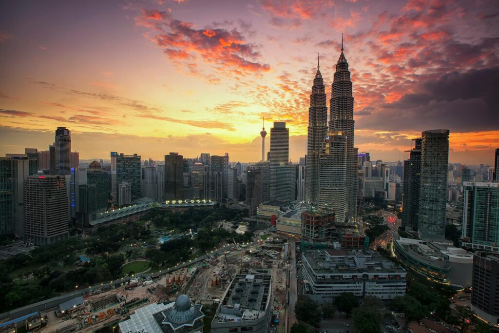 A breathtaking view of Kuala Lumpur's skyline featuring the Petronas Twin Towers at sunset.